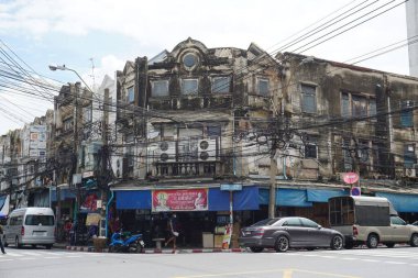 Eski yıpranmış bir köşe bina Bangkok 'ta araçlarla sokakta görülmüş.