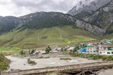 Jammu ve Kashmir 'deki Sonamarg Hill Trek vadisinde evleri ve nehirleri olan güzel bir dağ manzarası.