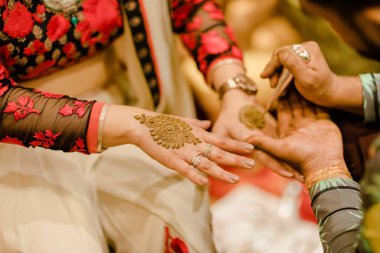 Geleneksel Hint düğünü sırasında ellerine kına dövmesi yaptıran bir kadın.