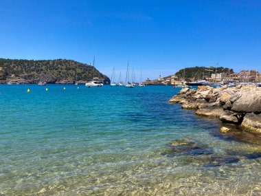 İspanya 'nın Mallorca adalarındaki bir limanda kayalık bir sahil ve mavi bir tatlı su