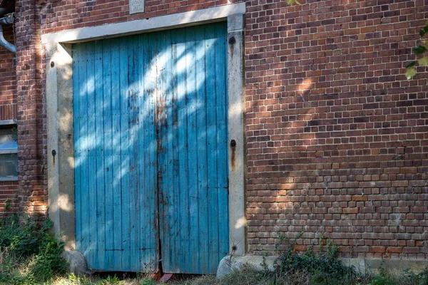 Старая Выветрившаяся Голубая Дверь Красной Кирпичной Стене Запечатленная Проблесками Солнечного — стоковое фото