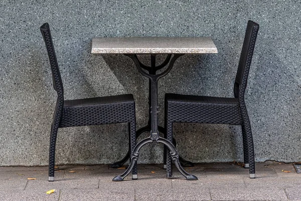 Uma Mesa Duas Cadeiras Pretas Perto Parede Bege Vazia Livre — Fotografia de Stock