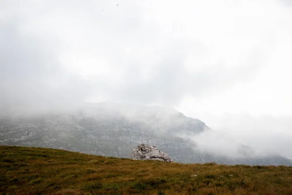 在雾蒙蒙的天气里 田野中的岩石 可以看到一座岩石山 — 图库照片
