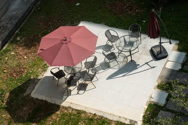 緑の公園の傘の下の椅子やテーブルの高角度ショット — ストック写真