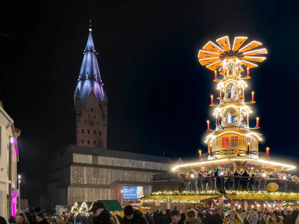 晚上在大教堂广场上的圣诞市场 一座巨大的圣诞金字塔矗立在大教堂前面 大家都在庆祝 — 图库照片