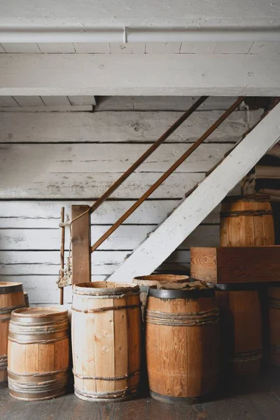 Eine Vertikale Aufnahme Alter Rustikaler Weinfässer Unter Der Weißen Holztreppe — Stockfoto