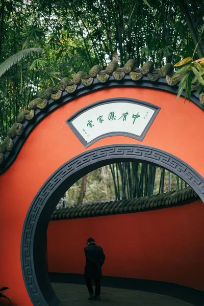 Pionowe Ujęcie Chińskiego Tradycyjnego Bambusowego Czerwonego Łuku Człowiekiem Chodzącym Tle — Zdjęcie stockowe
