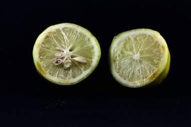 Siyah arkaplanda izole edilmiş kesilmiş bir limon