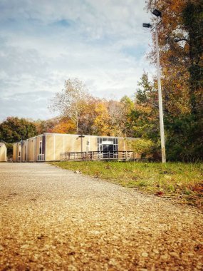 Yoğun ağaçlarla çevrili bir binanın havadan görünüşü