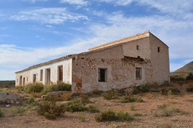 Kırsalda mavi gökyüzünün altında eski bir taş bina.