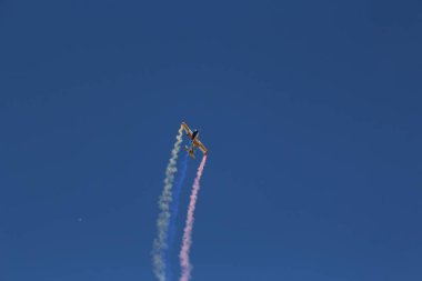 Bulutsuz mavi gökyüzünde uçan bir RC uçağının alçak açılı görüntüsü.