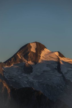 Mavi gökyüzünün altındaki dağ manzarası.