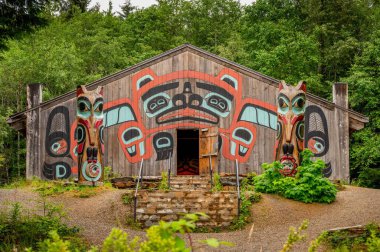Saxman, Alaska - July 29, 2022: Tlingit totem poles, long house and traditional art. clipart