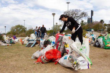 Nehir temizleme günü sırasında Parana Nehri 'nden çıkarılan çöpleri ayıran bir gönüllü.