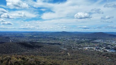 Orman tepeleriyle çevrili bir kasabanın kuş bakışı görüntüsü.