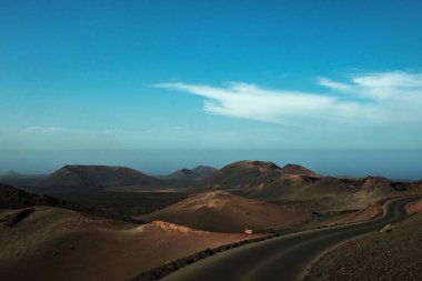 Dağları olan boş bir köy yolu manzarası. Timanfaya Ulusal Parkı, Kanarya Adaları, İspanya.