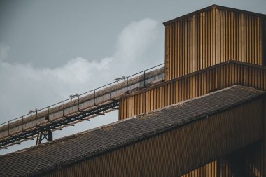 Kasvetli gökyüzüne karşı bir fabrika manzarası.
