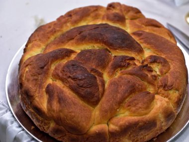 Beyaz bir masada bıçaklı Pogacha ekmeğinin üst görüntüsü.