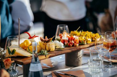 Restoran masasında gurme aperatifleri olan ahşap bir tabak.