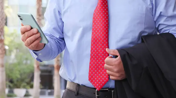 Biznesmen Czerwonym Krawacie Trzymający Komórkę — Zdjęcie stockowe