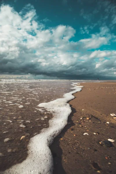 Zbliżenie Fal Myjących Wybrzeże Pod Błękitnym Niebem Chmur — Zdjęcie stockowe