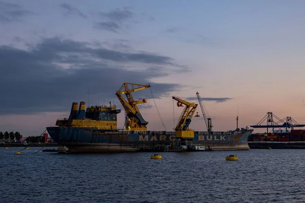 日没の青い時間に港で産業内陸輸送カラフルなクレーン 重機械アーキテクチャと物流コンセプトのエンジニアリング — ストック写真