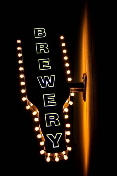 Ein Beleuchtetes Brauereischild Einer Wand Vor Dunklem Hintergrund — Stockfoto