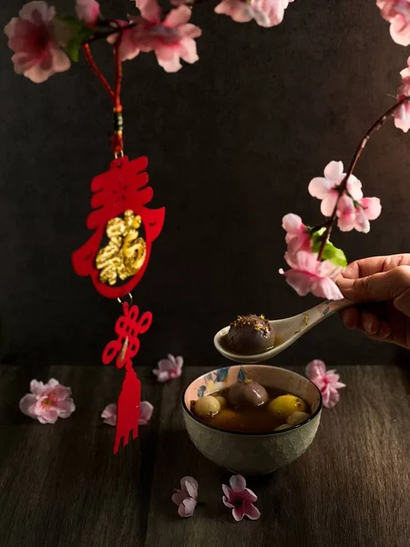 ピンクの花で飾られたテーブルの上にTangyuanのボウルの垂直閉鎖 — ストック写真