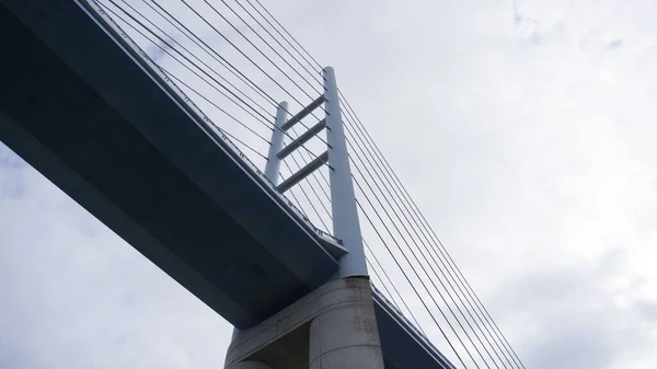 Χαμηλή Γωνία Θέασης Τεράστιας Κρεμαστής Γέφυρας Ενάντια Στον Κυκλοθυμικό Ουρανό — Φωτογραφία Αρχείου