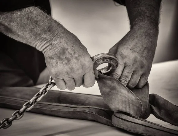 フックを産業用スリングに接続する男の手のセピア — ストック写真