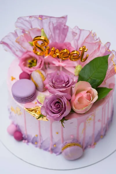 マカロンと花で装飾された美しいピンク色の誕生日ケーキのフラットレイアウト — ストック写真