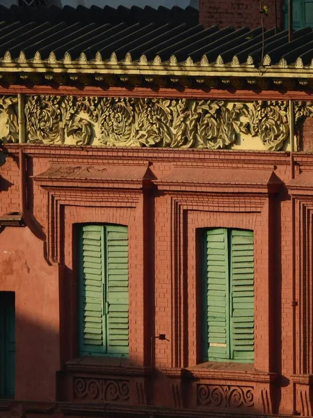 stock image A closeup shot of a red brick building with green window shutters