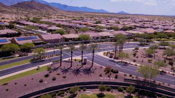 An aerial view of Goodyear, Arizona city with clean asphalt roads, low buildings and green trees
