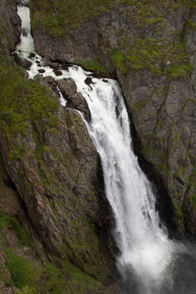 一个巨大的瀑布从茂密的绿色山坡上流过 — 图库照片