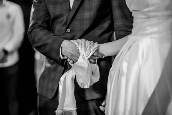 新婚夫妇牵着手 用丝绸包裹着的一张灰白的照片 — 图库照片