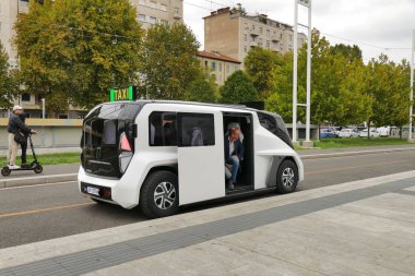 Beyaz bir ETIOCA tam elektrikli minivan taksisinde oturan insanların görüntüsü.