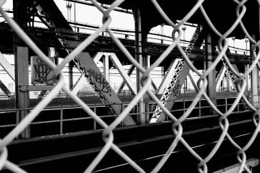 Williamsburg Köprüsü Tramvay Terminali 'nin güzel gri tonlu manzarası tel örgülerden geçiyor.