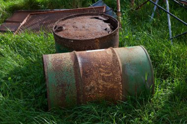 Yeşil çimlerin üzerindeki iki paslı varil - ekoloji kavramı