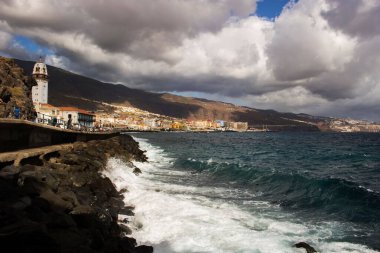 Bulutlu gökyüzünün arka planına karşı şehir binalarının manzarası. Candelaria, Tenerife, İspanya.