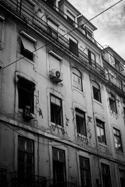 Rua Augusta, Lizbon, Portekiz 'de terk edilmiş eski bir binanın ön cephesinin dikey gri tonlu görüntüsü.