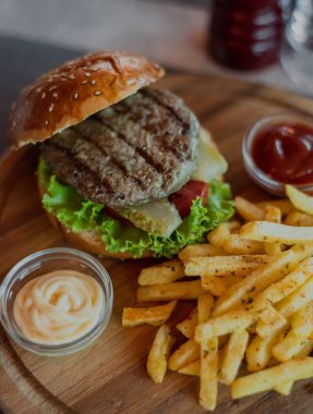 Birinci sınıf seçkin bir restoranın ortamında hazırlanmış bir hamburger ve patates kızartması.