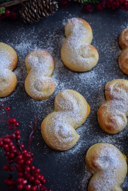 İsveç çöreklerinin tepesinde pudra şekeri ve Noel süslemeleriyle dikey bir görünümü