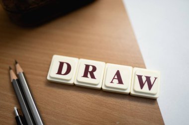 Kağıt ve kalemlerle ahşap bir masanın üzerine çizilmiş karolar..