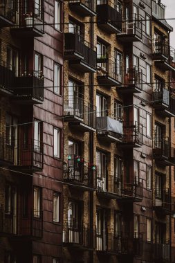 Balkonlu bir apartmanın dikey görüntüsü.