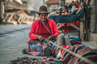 Peru 'daki Cusco pazarında oturan bir kadın.