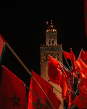 Gece Kutubiyya Camii 'nin arka planında birden fazla Fas bayraklarının dikey çekimi