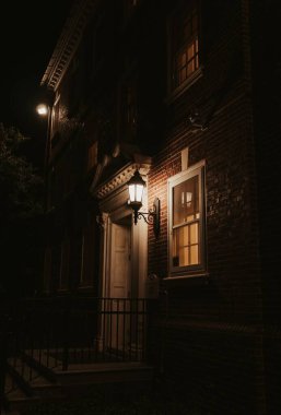 Geceleri ışıklarla dolu tahta bir kapının dikey görüntüsü.