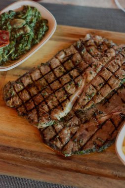 Birinci sınıf bir biftek lokantasının ortamında hazırlanmış leziz bir bifteğin dikey çekimi.