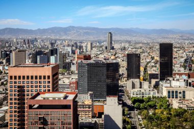 Şehir merkezindeki Mexico City 'nin havadan nefes kesen manzarası, güneşli bir günde arka planda bir dağ.