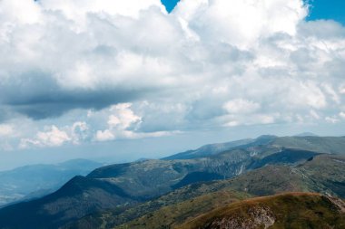 Ukrayna 'nın üzerinde yüzen bulutlarla dolu bir vadideki Karpat Dağları manzarası.